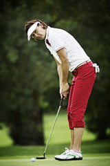 Female golfer putting