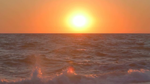 Sun setting over the water with light glimmering on waves