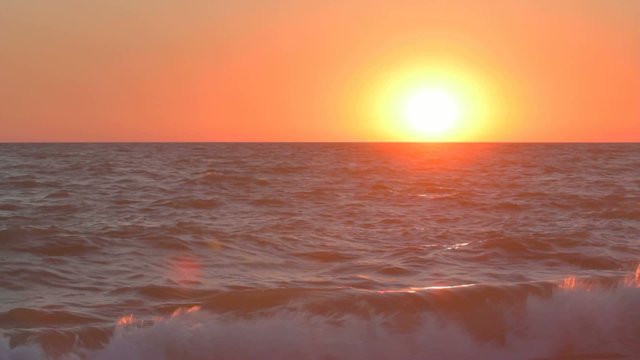 Sunset over the sea water with light glimmering on waves