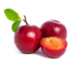 Two fresh plums and a half with leafs