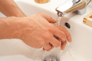 Gründliche Hand Reinigung - Mann wäscht sich die Hände unter fließendem Wasser