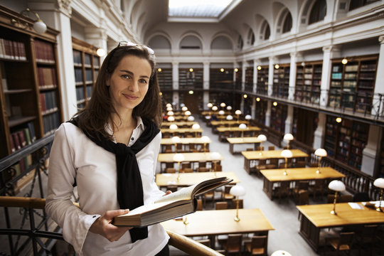 Friendly Student Reading In Library Upstairs.