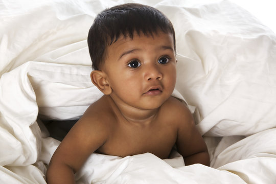 Sweet Indian baby lying on blanket