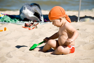 young boy playing in the sand on the beach