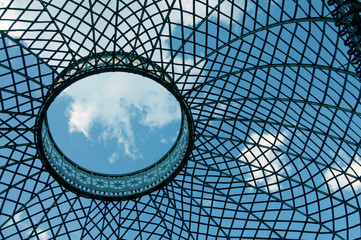 Lattice dome on the background of sky and clouds.