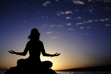 beauty girl in lotus pose on sunrise beach