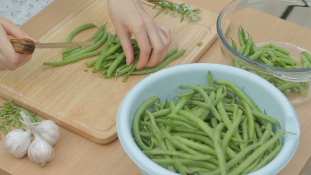 Cutting the remaining stems from fresh green beans outdoors