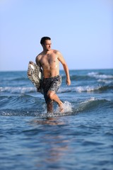 Fototapeta premium Portrait of a young kitsurf man at beach on sunset