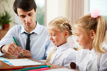 Fototapeta premium Teacher helping students with schoolwork in school classroom. Ho