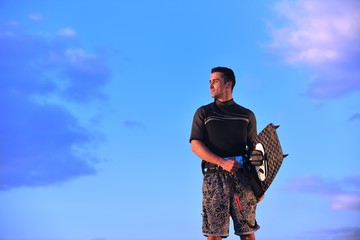 Naklejka premium Portrait of a young kitsurf man at beach on sunset