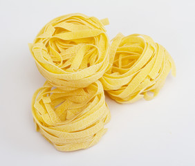 heap of raw dry nest pasta over white background