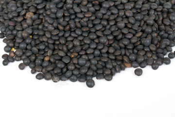 Heap of black lentil isolated on white