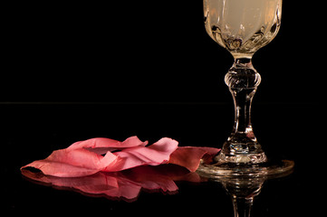 Copa de cristal y pétalos de rosa