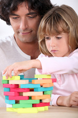 Father and daughter building a tower of blocks