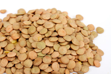 Pile of green lentils from low perspective isolated on white.