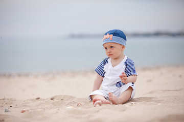 baby sitting on the sand at the beach