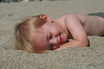 Obraz na płótnie Canvas enfant allongé dans le sable