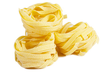 heap of raw dry nest pasta over white background