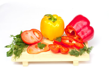 Pepper, tomato with dill and parsley on the wood desk isolated