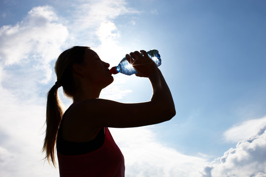 Sportlerin trinkt aus Wasserflasche