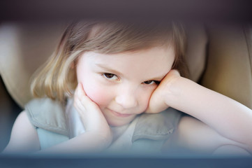Obraz premium Adorable little girl sitting in a car seat