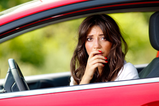 Young Pretty Scared Woman In The Car