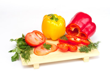 Pepper, tomato with dill and parsley on the wood desk isolated