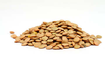 Pile of green lentils from low perspective isolated on white.