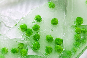 Fototapeta na wymiar green peas in cracked ice chunks