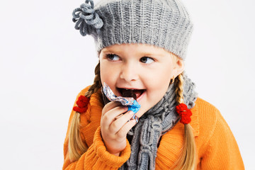 Lovely little girl eating a candy