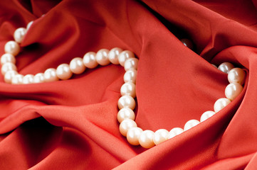 Pearls necklace on satin background