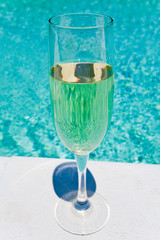 glass of white wine on pool board outdoor