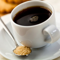 Cup of balck coffee with brown sugar