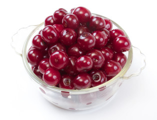 Bowl with ripe cherries. Isolated on a white background.
