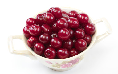Bowl with ripe cherries. Isolated on a white background.