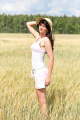 gorgeous girl standing over wheat field in sunny day