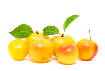 Pile of yellow plums with leafs