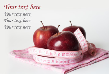 Three red juicy apples and measuring tapeяблоко