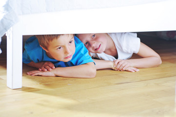 Kinder verstecken sich unter Bett
