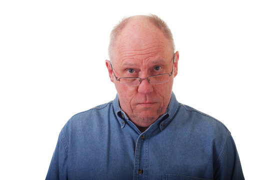 Older Balding Man in Blue Shirt Looking Over Glasses