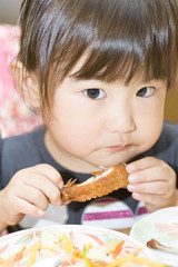 鶏肉を食べる子供