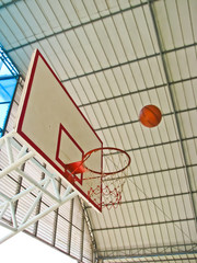 a ball going to basketball hoop at indoor stadium