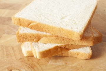 bead, sliced white bread on wood plate.