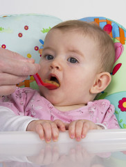 Baby girl eating puree