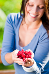 Fresh raspberries hold hand cheerful smiling woman