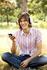 Smiling handsome man with headphones at outdoors