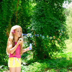 Obraz premium Children blowing soap bubbles in outdoor forest