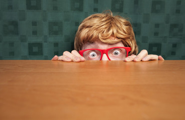 Scared nerd hiding behind a desk - 34503861