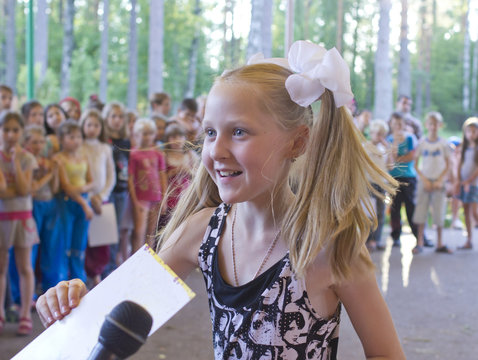 Little Girl Gives An Interview In Front Of Group Of Children