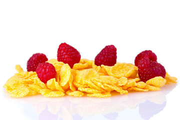 tasty cornflakes and raspberries isolated on white